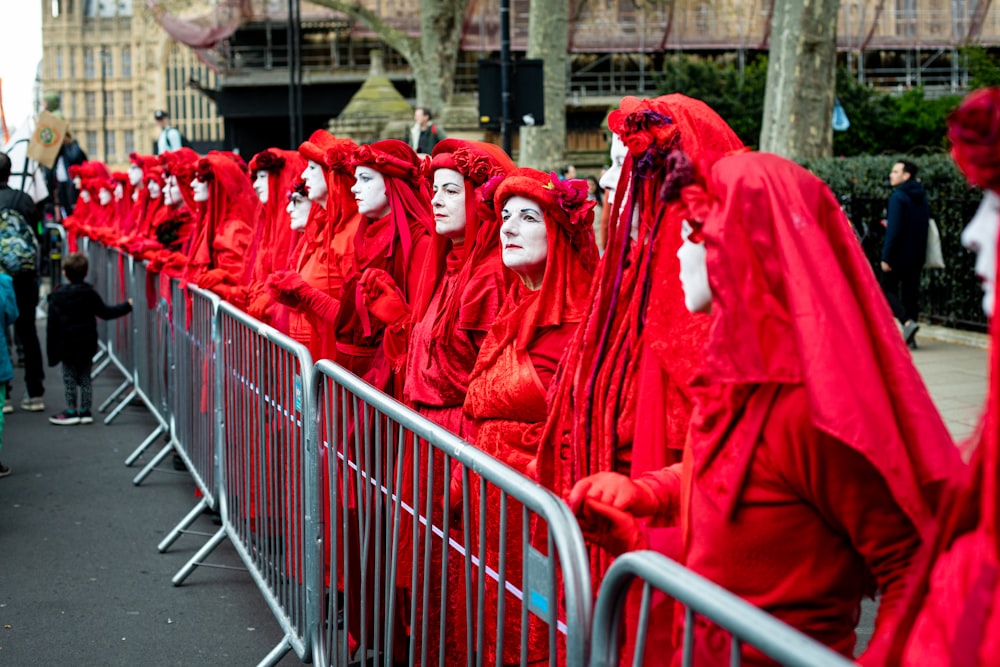 a group of people in red costumes lined up behind a fence
