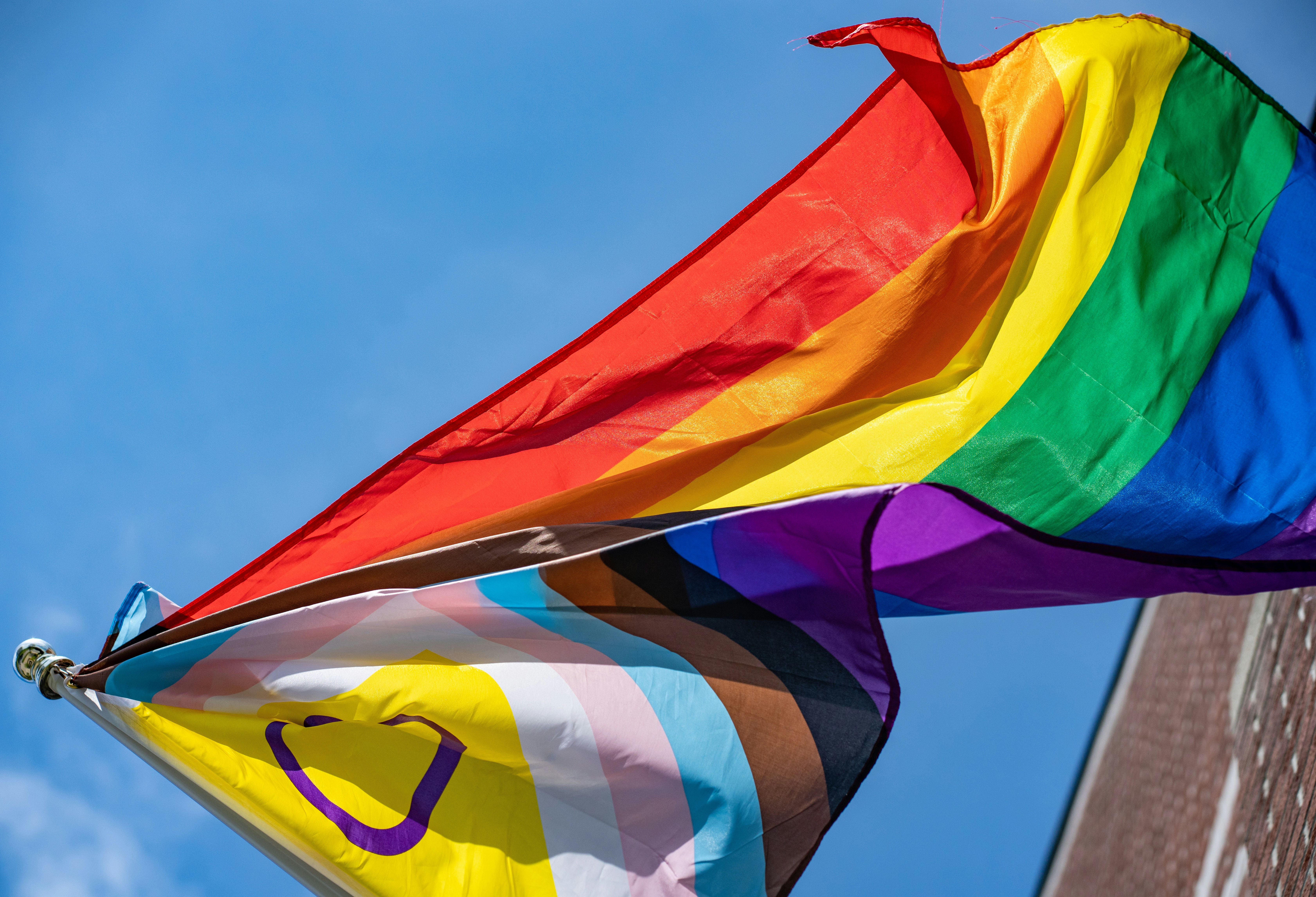 a rainbow colored kite flying in the sky