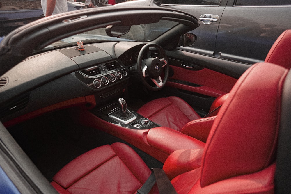 the interior of a sports car with red leather seats