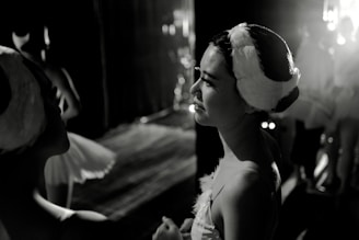 A close-up backstage moment showing actors preparing with focused expressions in a cozy theatre setting