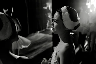 An intimate backstage moment showing actors preparing costumes and makeup under soft lighting.