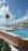 A sunlit terrace overlooking the private pool with turquoise ocean in the background.