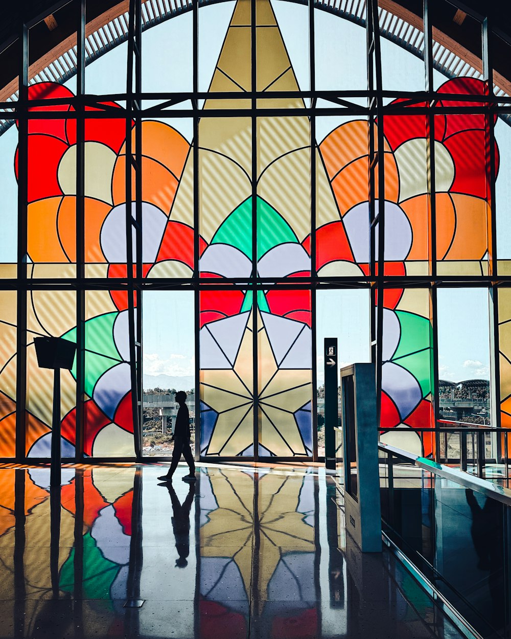 a person standing in front of a large stained glass window