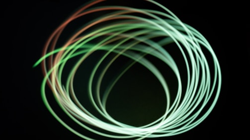 A group of people moving together in a circle, their forms blending into light trails.