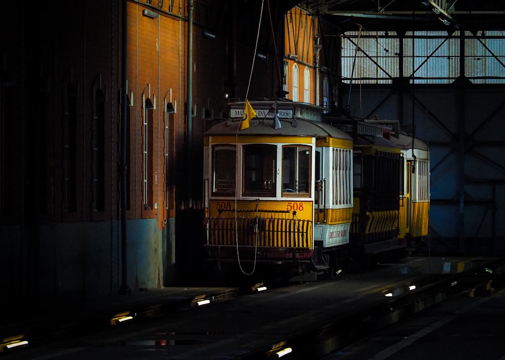 a yellow and white train sitting in a train station