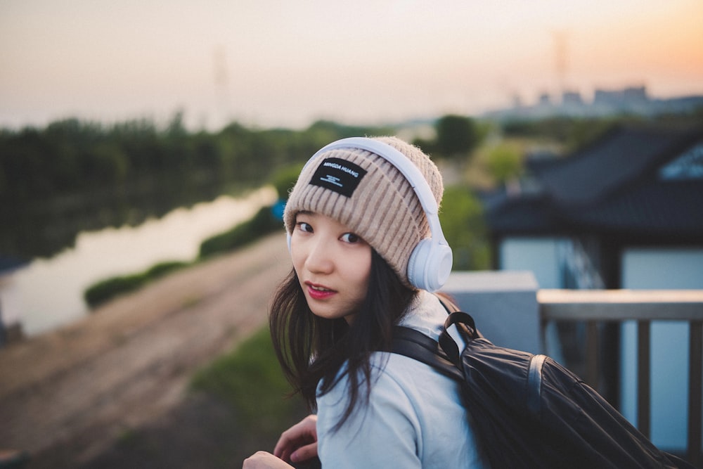 a woman with a backpack and a beanie on