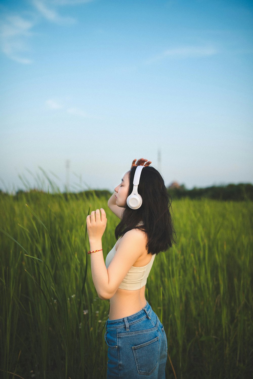 a woman wearing headphones standing in a field