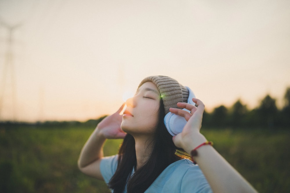 a woman in a field with a cell phone to her ear