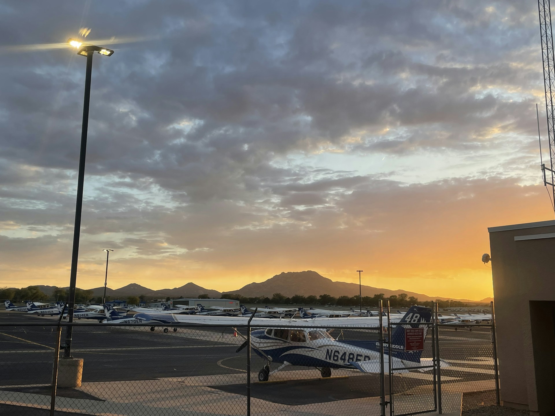Aerial view of the Fly Ville runway and surrounding luxury hangars at sunset, highlighting the exclusive fly-in community layout.