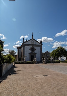 A peaceful church courtyard bathed in warm golden light with subtle Syriac crosses and motifs.