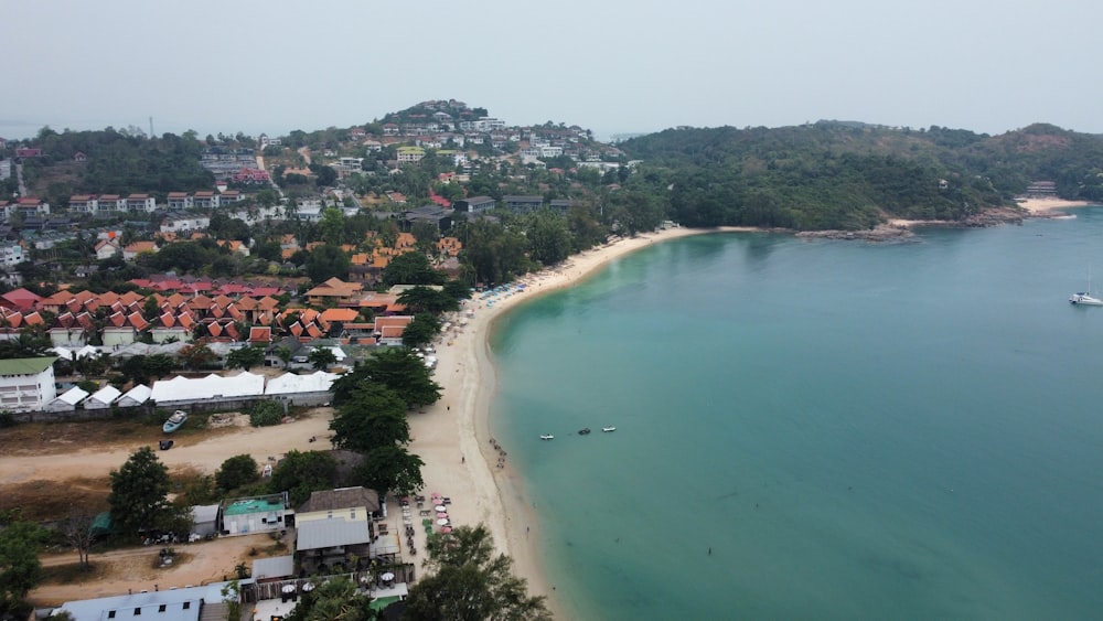 an aerial view of a beach with a boat in the water