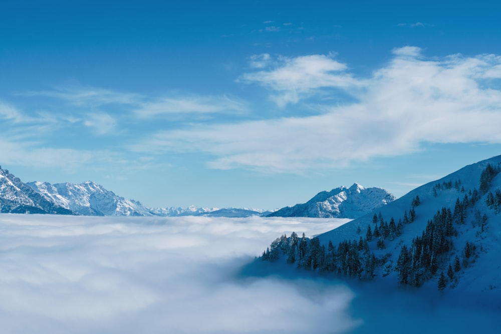 a mountain covered in snow and surrounded by clouds