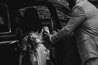a man in a suit getting out of a car