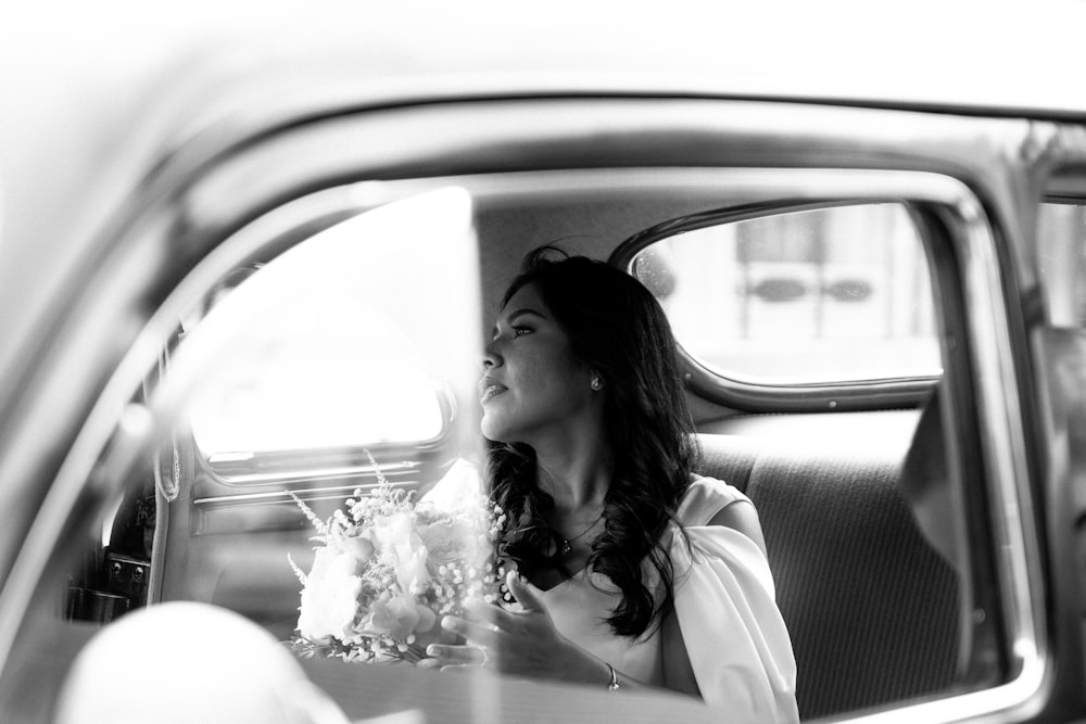 a woman sitting in the back seat of a car