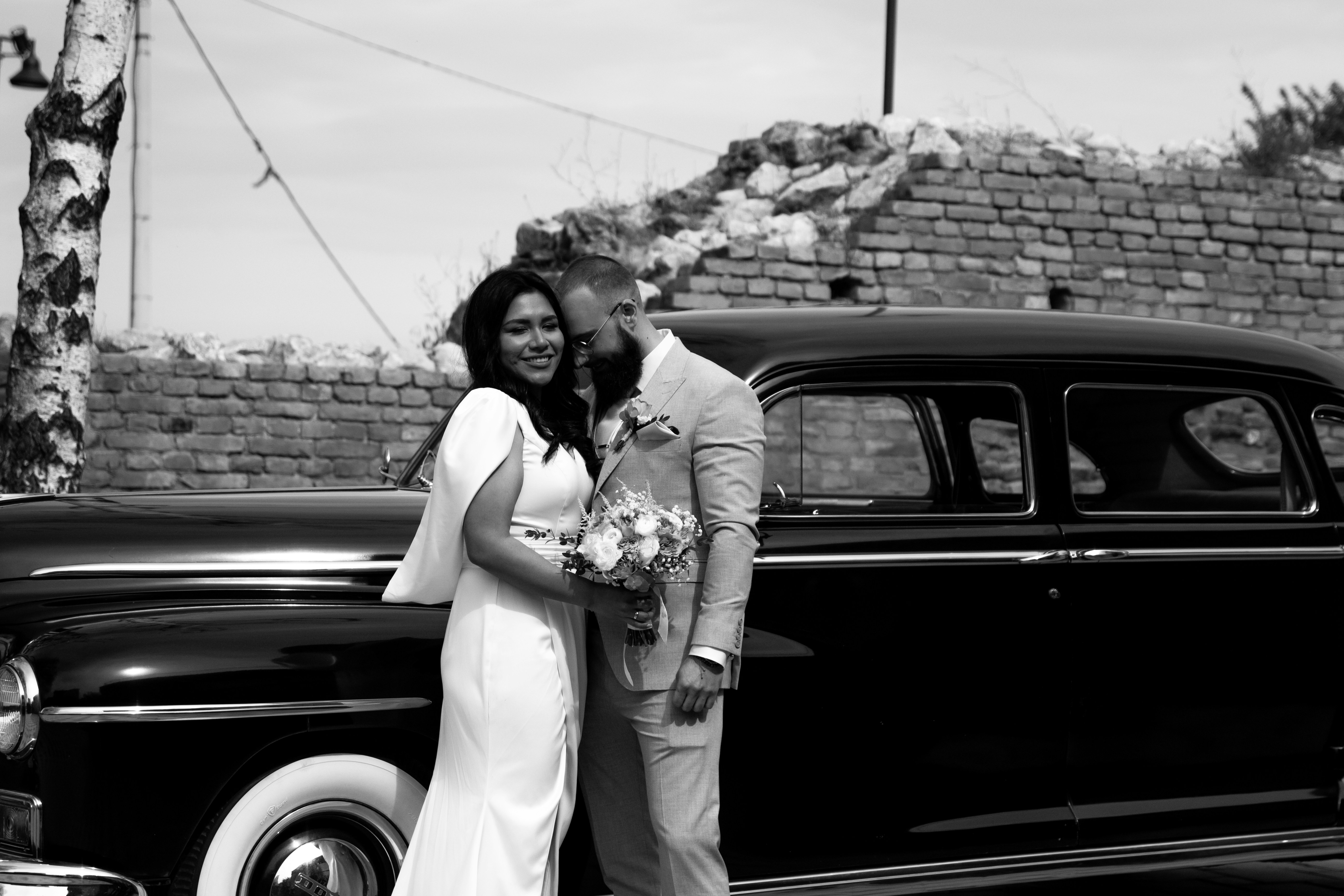 Young couple standing proudly beside their freshly purchased car.