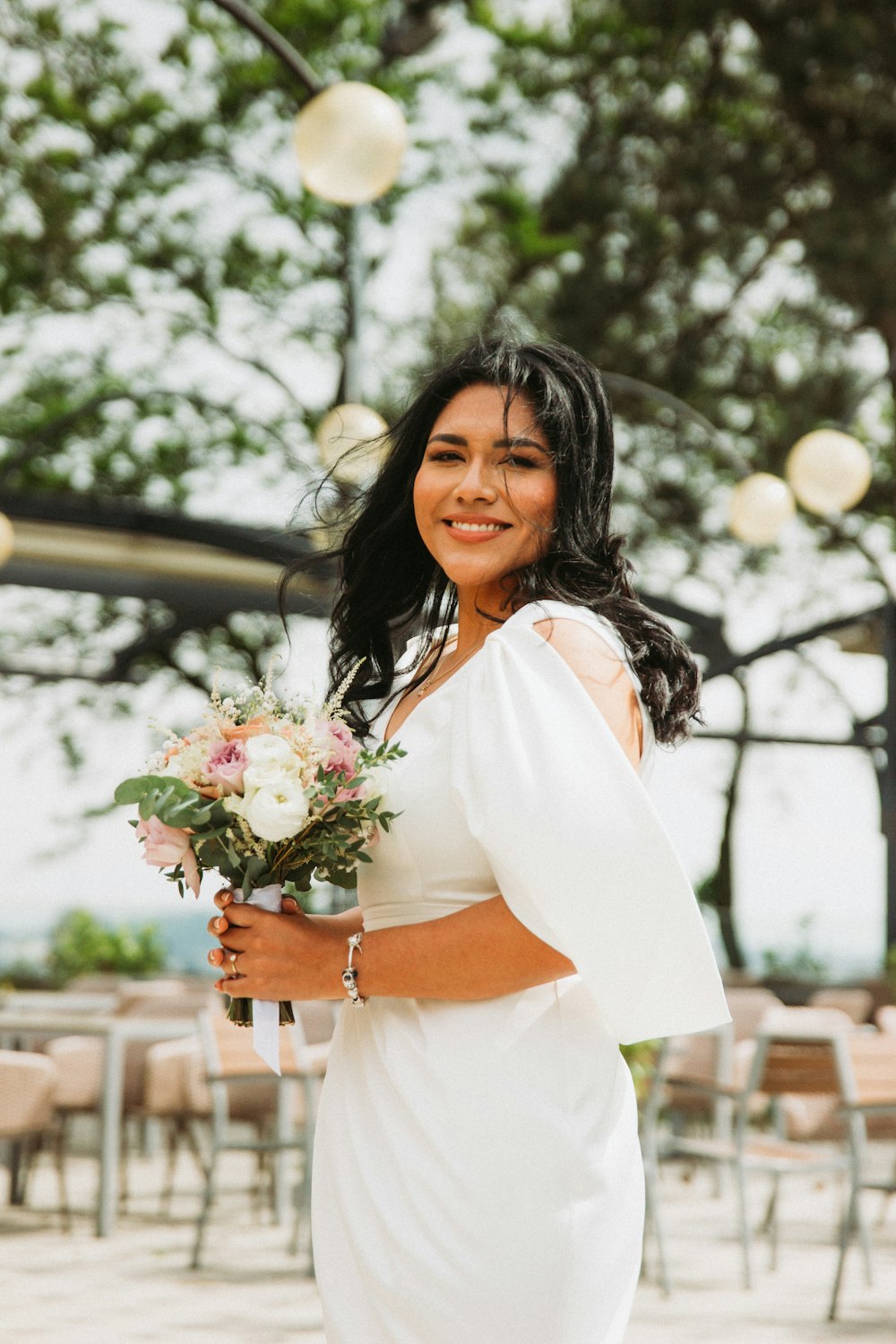 a woman in a white dress holding a bouquet of flowers