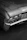 Close-up of a shiny, perfectly repaired bumper on a black car parked near a London landmark.