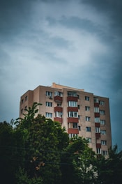 a tall building with lots of windows next to trees