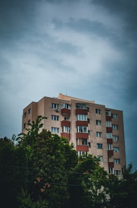 a tall building with lots of windows next to trees