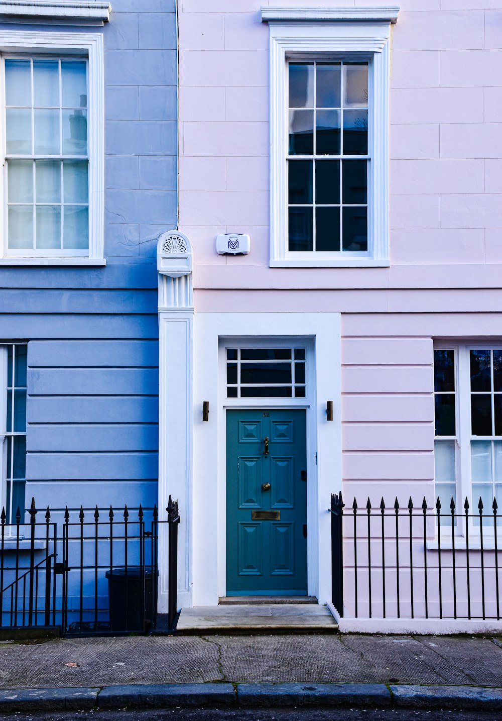a blue and pink building with a blue door