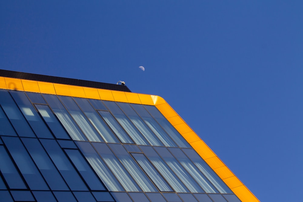 a very tall building with a half moon in the sky