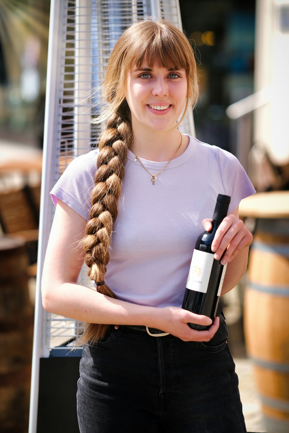 a woman holding a bottle of wine and smiling