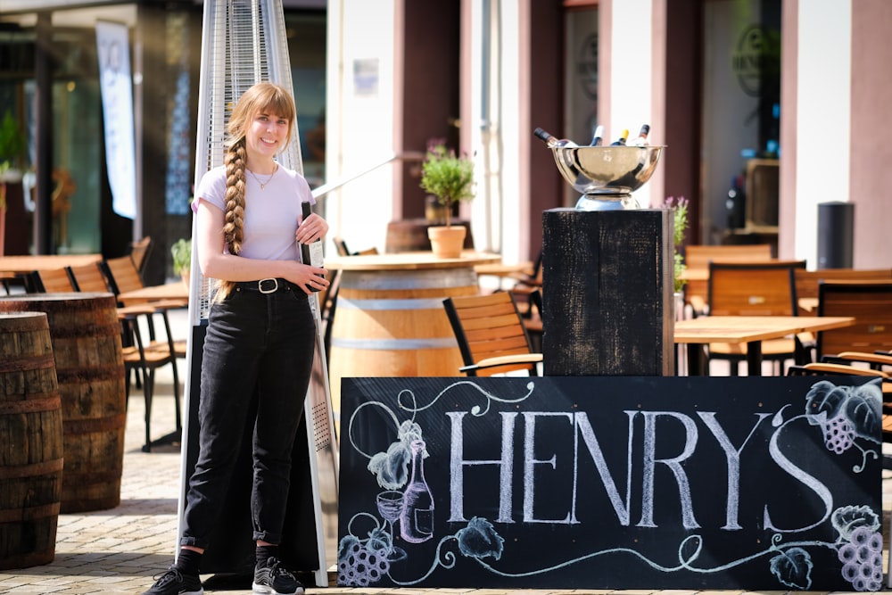 a woman standing next to a sign that says henry's