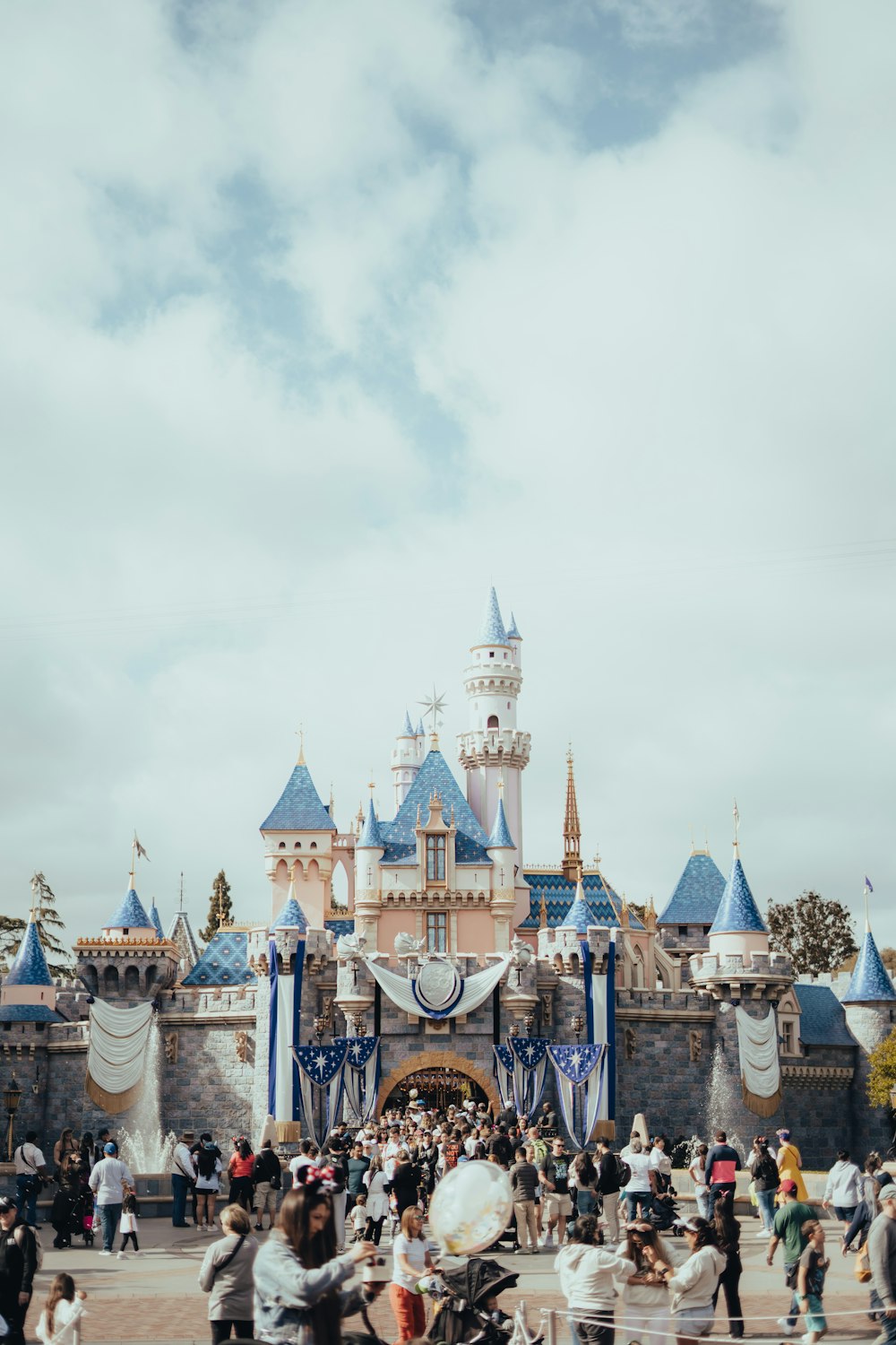 a crowd of people standing in front of a castle