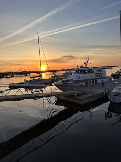 A vibrant sunset view over the Dubai Marina skyline with boats gently floating on the water.