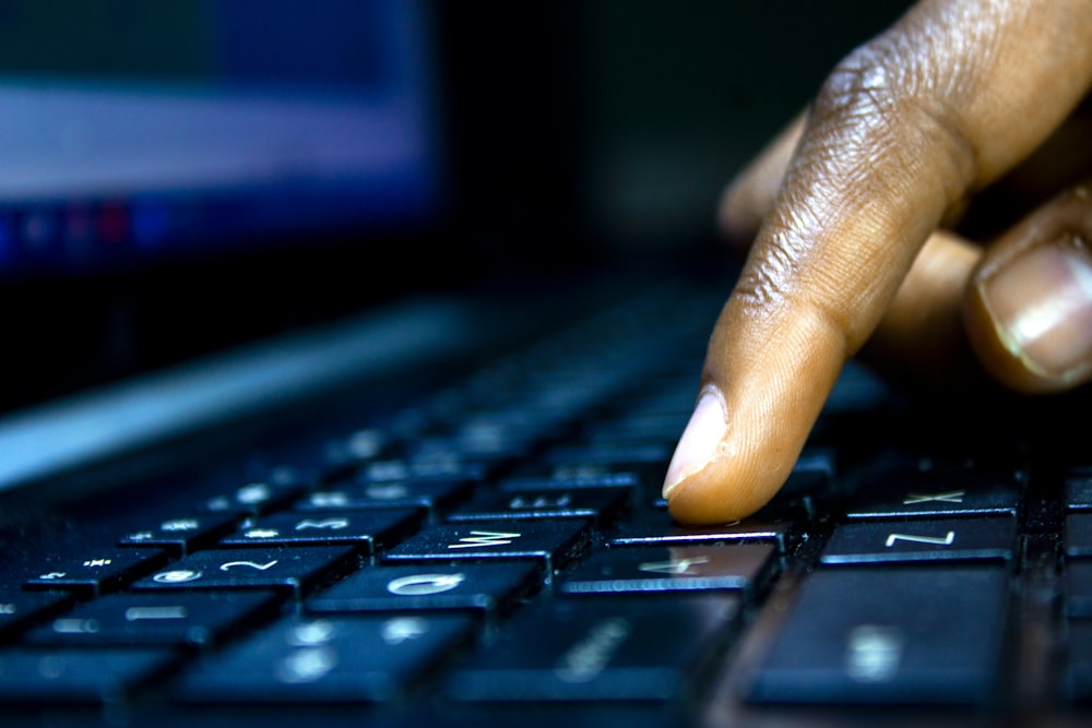 a close up of a person typing on a laptop