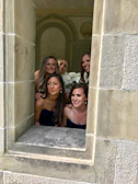 Bridesmaids dressed in powder blue, smiling warmly beside Adrianna.