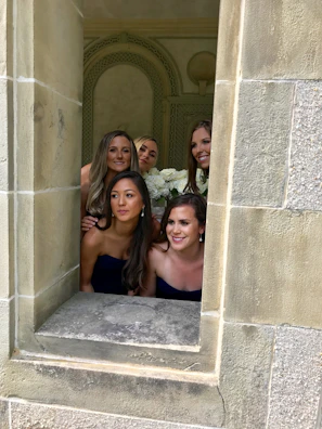 Bridesmaids dressed in powder blue, smiling warmly beside Adrianna.