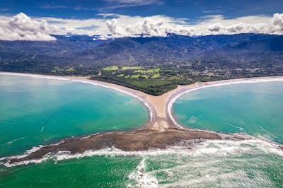 an aerial view of a beach and mountains