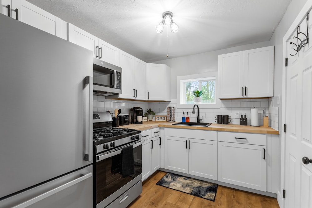 a kitchen with white cabinets and stainless steel appliances