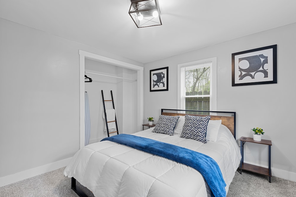 a bedroom with a white bed and a blue blanket