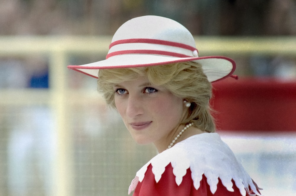 Una donna in un vestito rosso e bianco e cappello