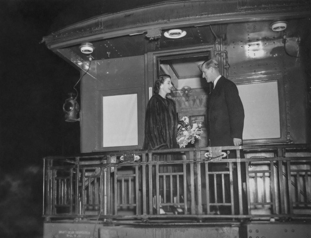 a couple of men standing on top of a balcony