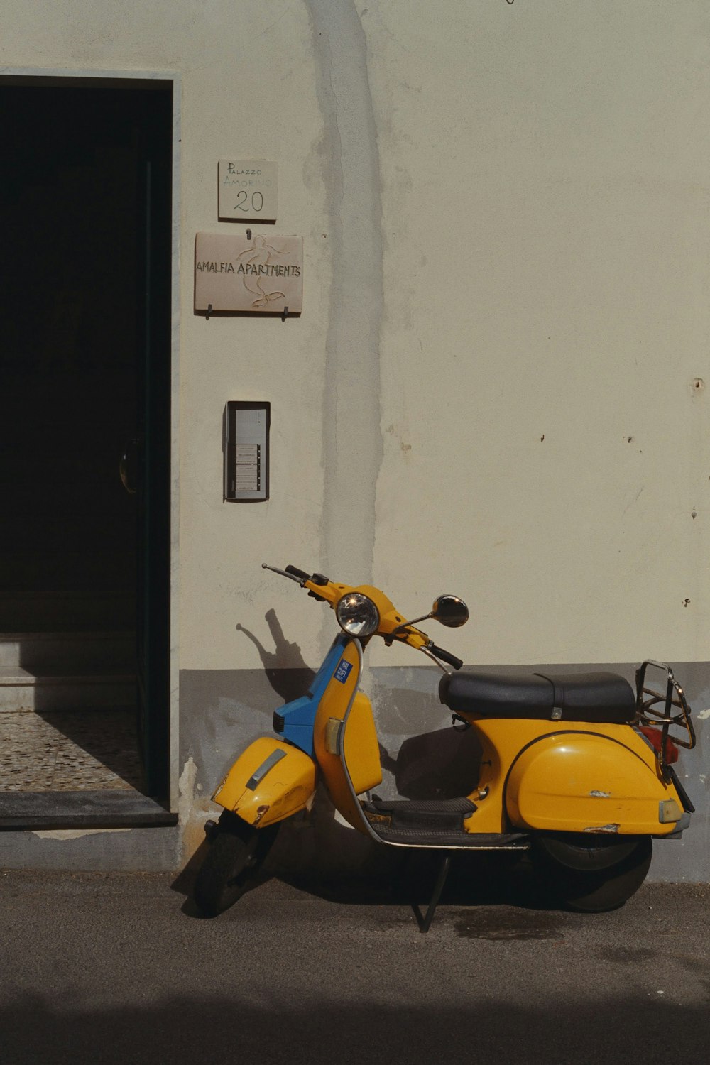 a yellow scooter parked in front of a building