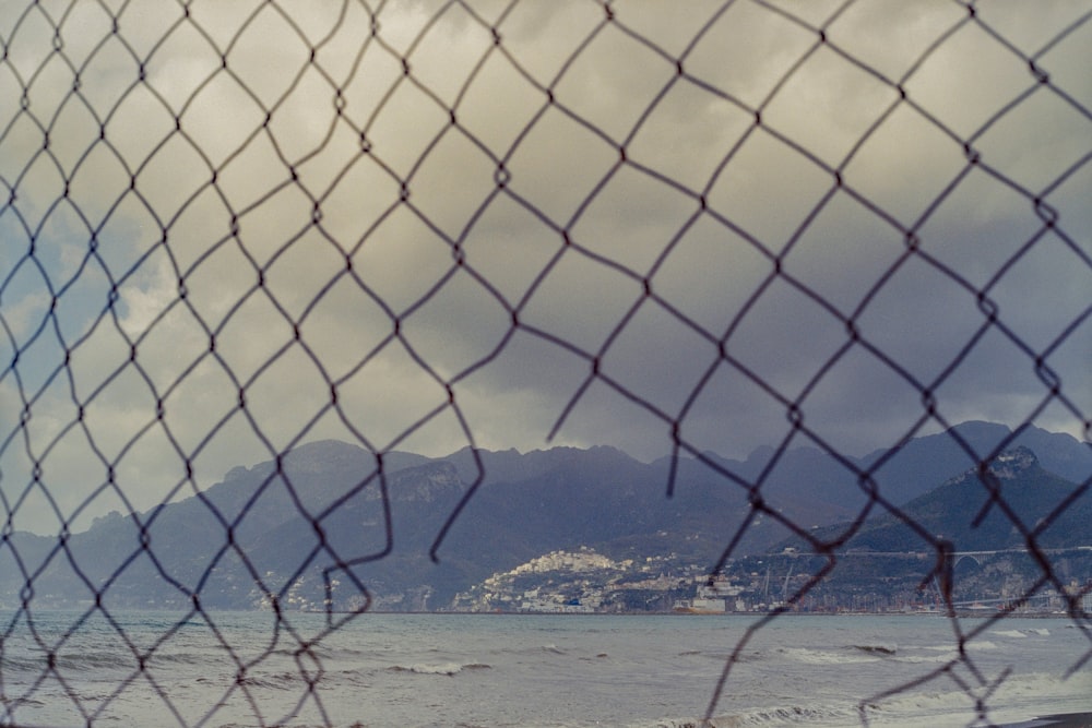 a view of a beach through a fence