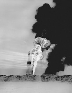 a black and white photo of smoke coming out of a pipe