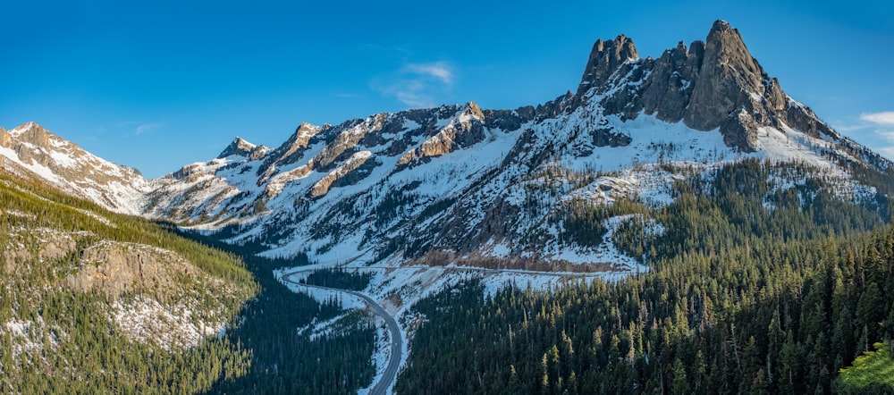 Una montaña cubierta de nieve con un camino sinuoso en primer plano
