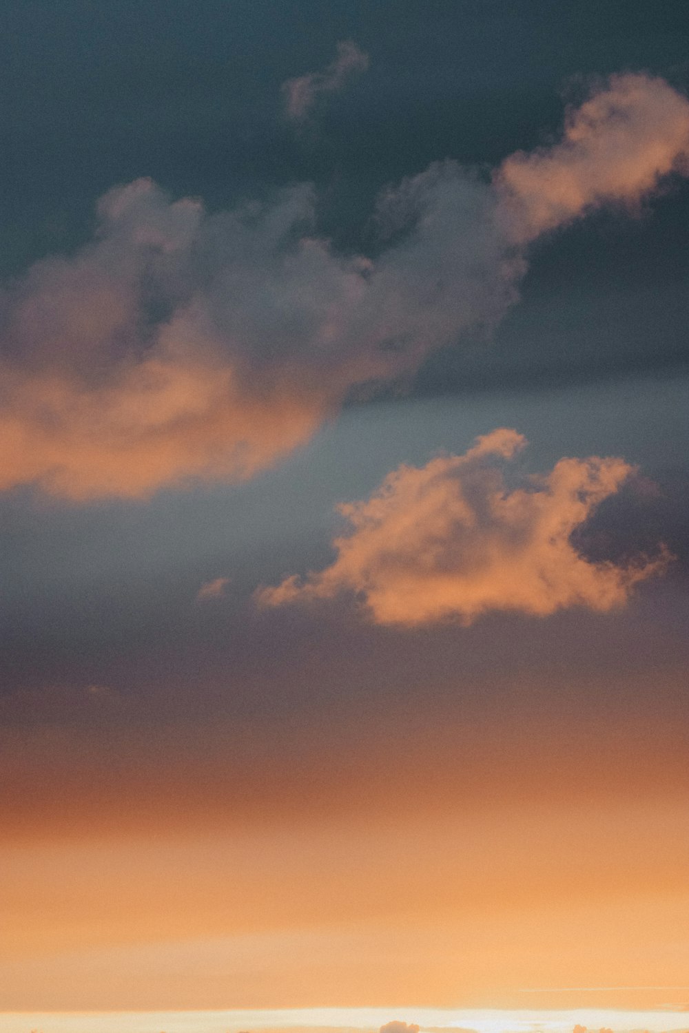 a plane flying in the sky at sunset