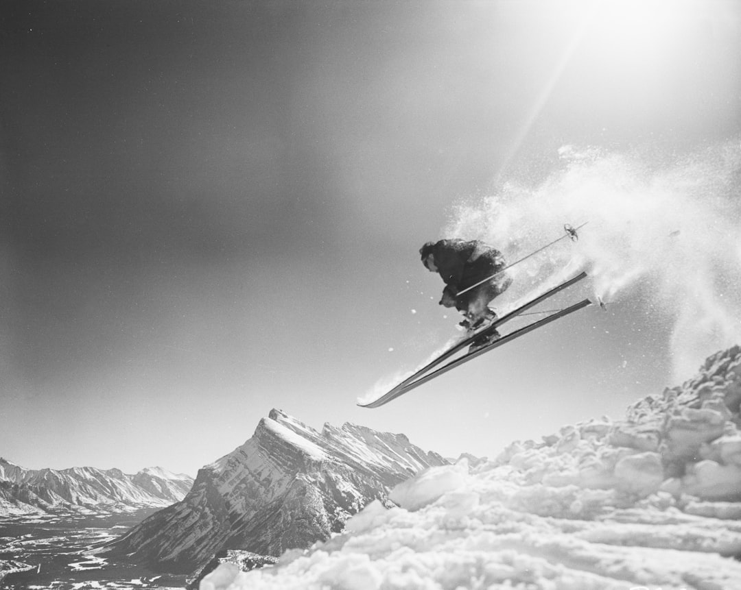 a skier is in mid air over the snow, Skiing at Mt. Norquay Banff National Park. Alberta Public Affairs Bureau, PA229.5 Taken in March 1956