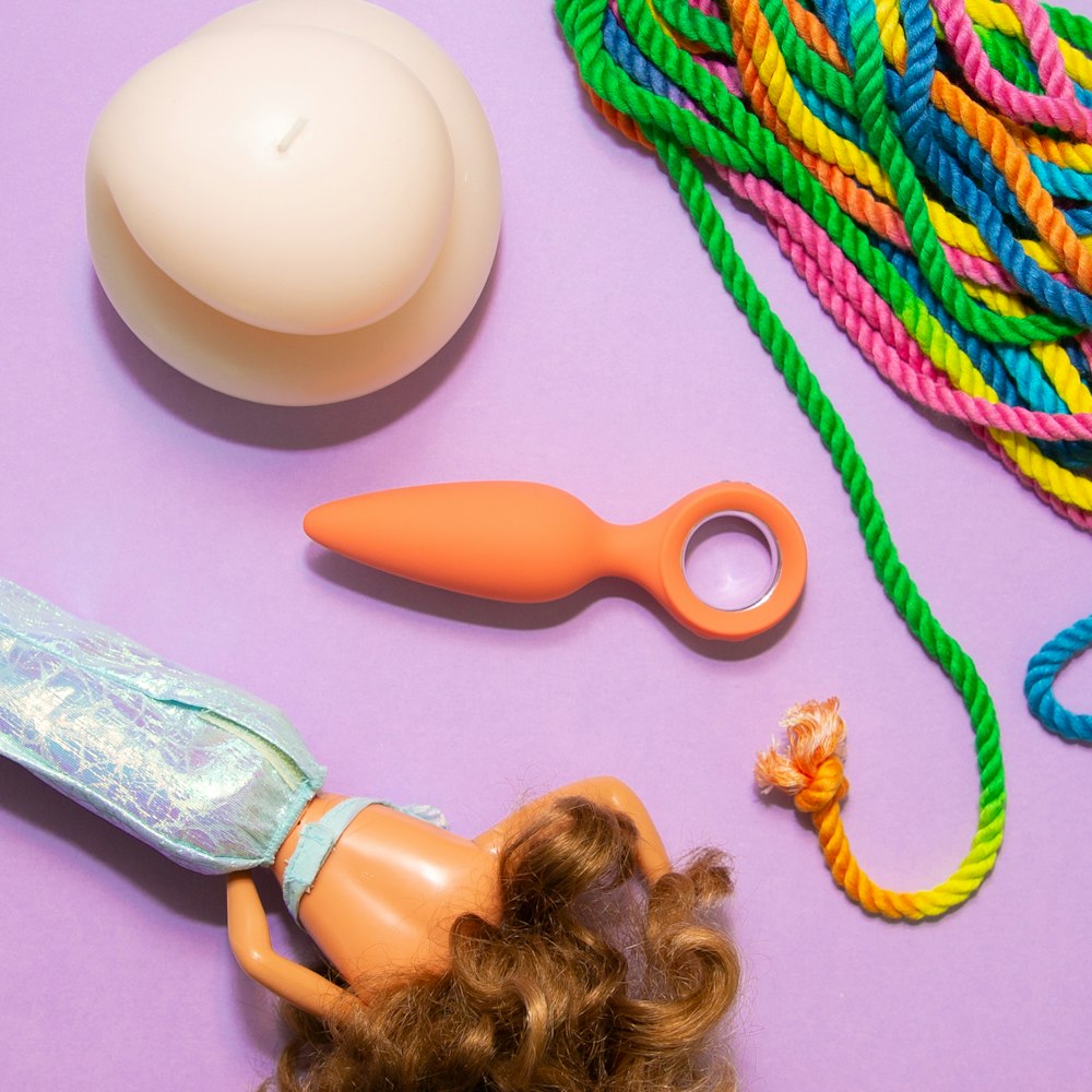 a doll laying on top of a table next to a pair of scissors