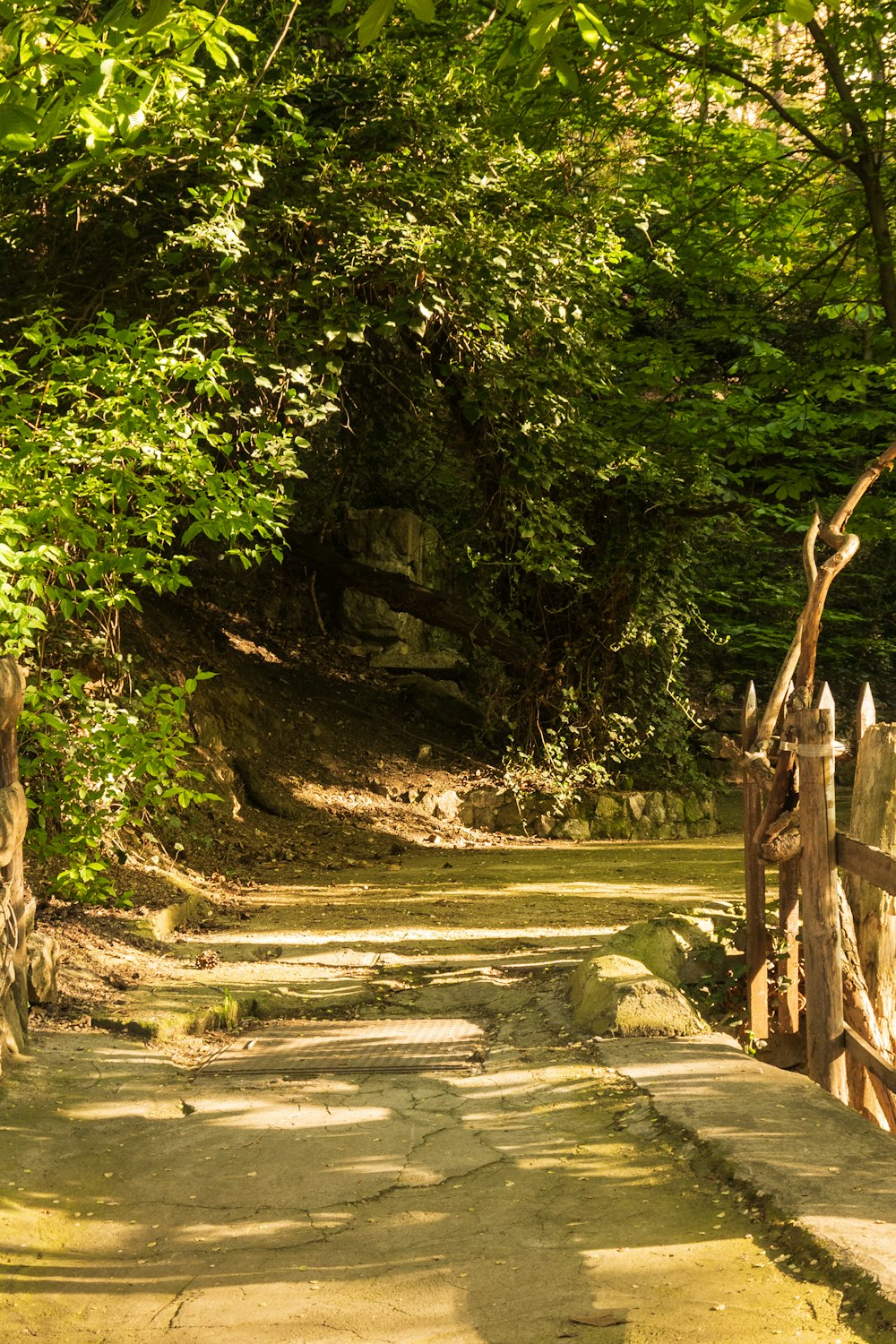 a wooden gate in the middle of a dirt road