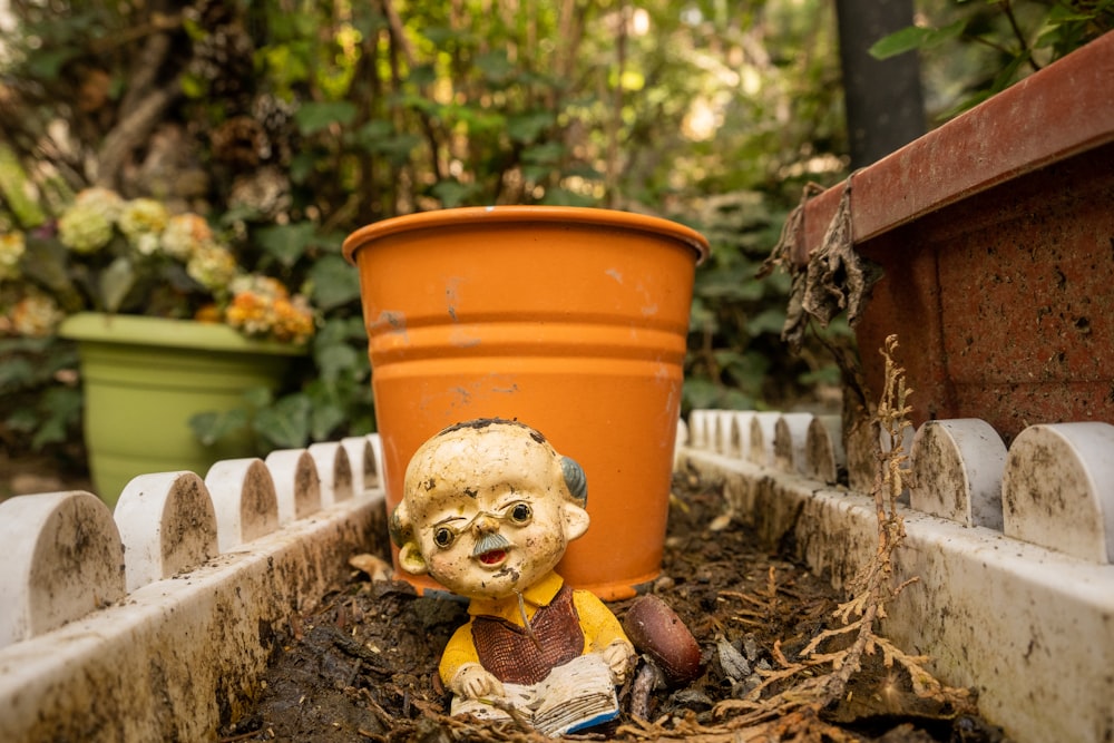 a statue of a man sitting in a flower pot