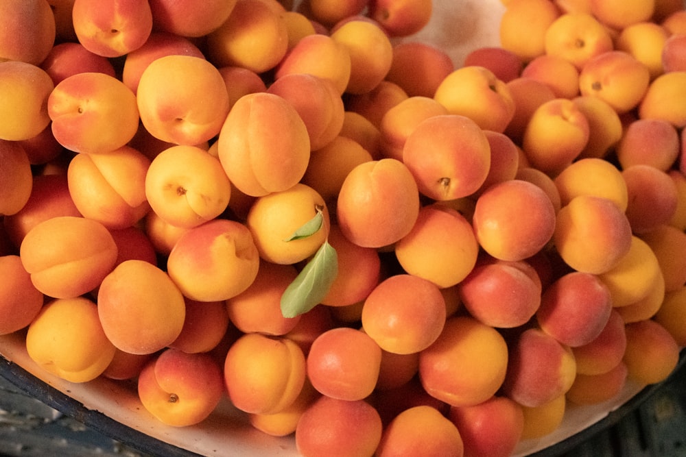 a bunch of apricots in a bowl on a table