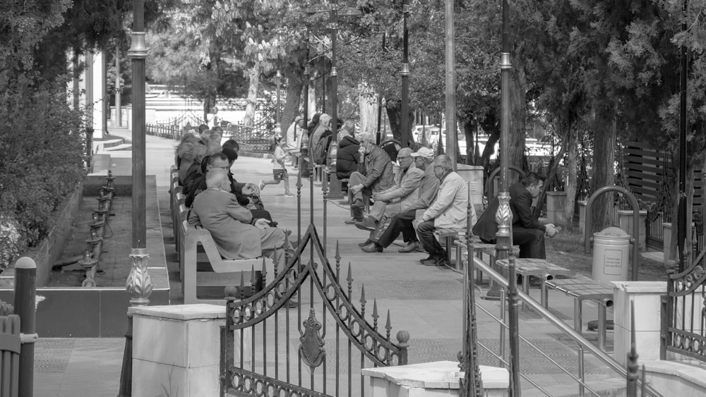 a black and white photo of people sitting on benches