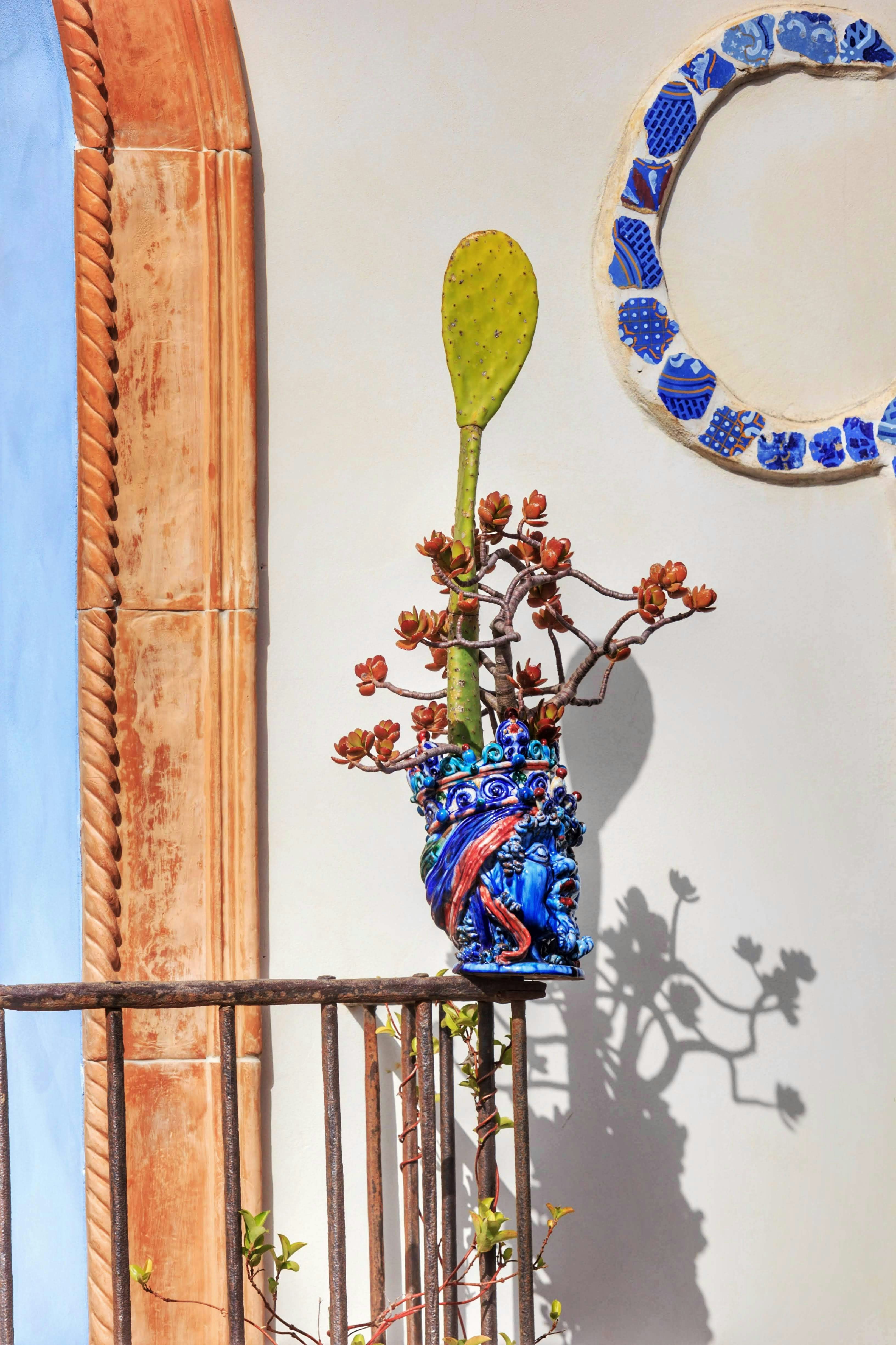 a vase with a plant in it sitting on a balcony