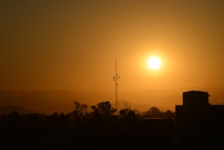 A warm sunrise over Salem with a radio tower broadcasting light beams.